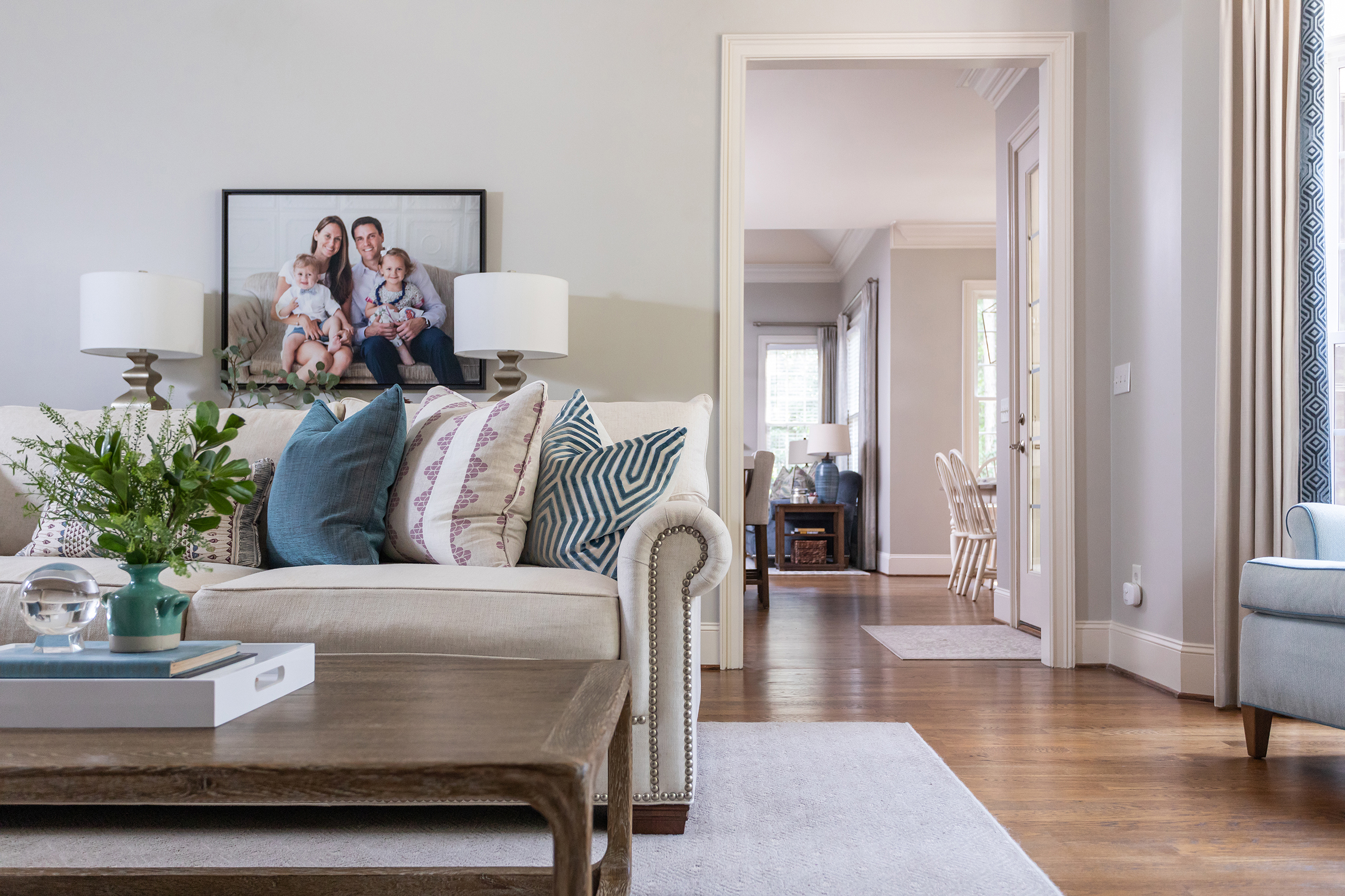 family portrait, printed pillows, nailhead trim sofa, bright living room, full service design