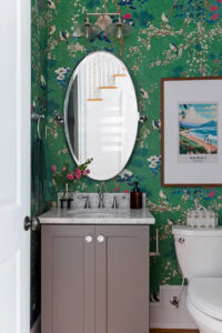 Gorgeous green wallpaper in powder room, featuring vintage travel art